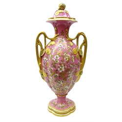  Large Royal Crown Derby two handled vase and cover, the lobed ovoid shaped body profusely decorated with Jasmine flowers and gilded foliage on pink ground with two naturalistic gilded handles and leaf terminals on a quatrefoil base, shape no. 207 and printed marks, H54cm x W25cm   