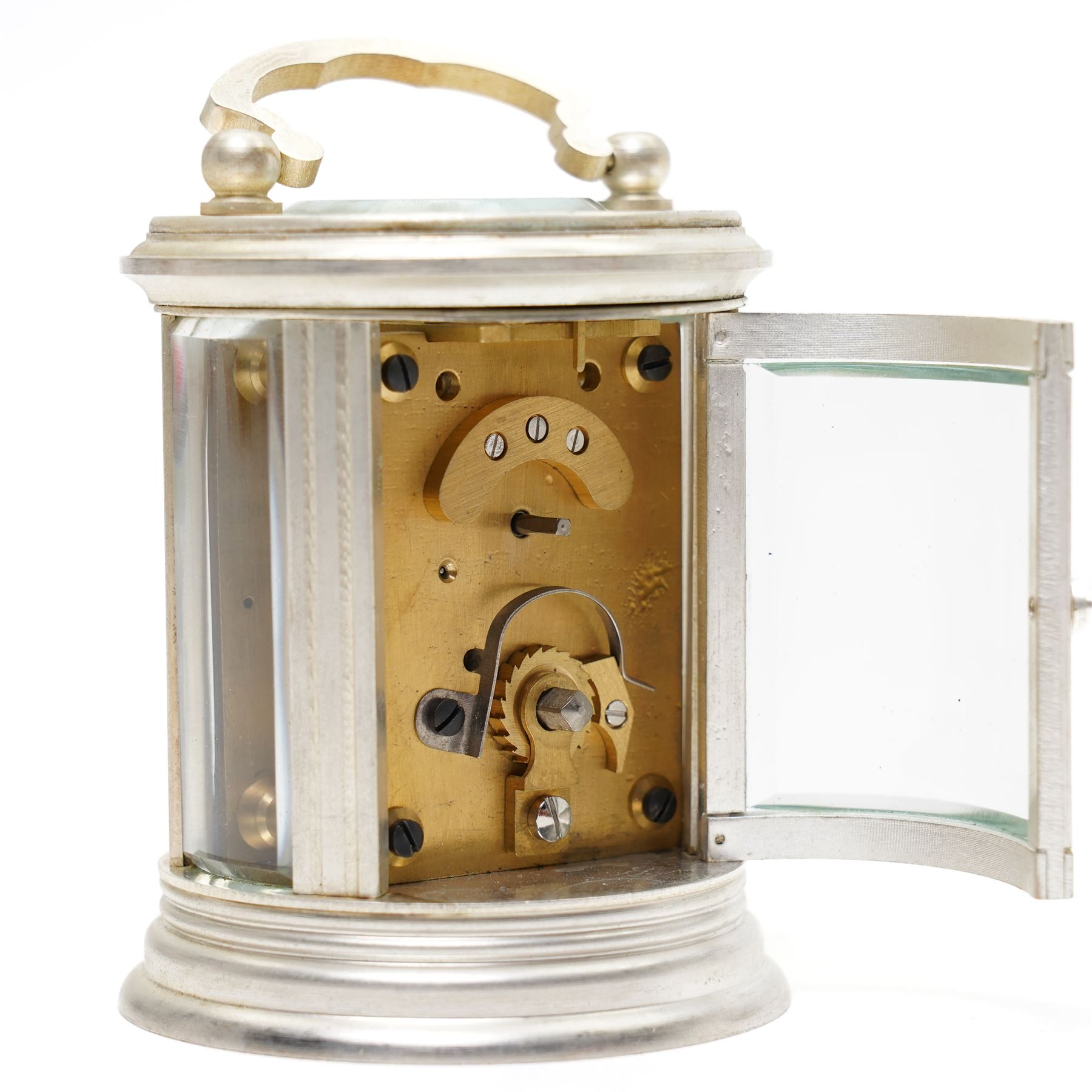 20th century-Silver plated 8-day timepiece carriage clock in an oval case, enamel dial with Roman numerals, minute track and steel moon hands, with an oval viewing class to the lever platform escapement. With key.