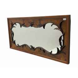 Late Victorian figured walnut mirror, in moulded surround, the shaped aperture surrounded by carved trailing foliate mounts