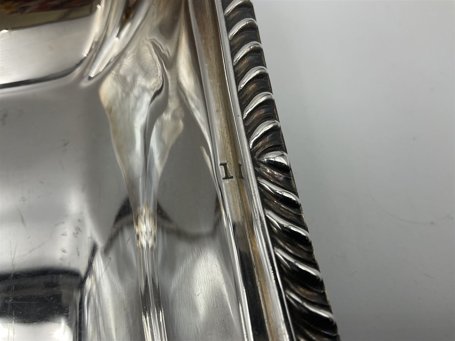 Early 20th century silver entree dish and cover, of rectangular form with shaped corners and oblique gadrooned borders to base and cover, the cover with loop 'bamboo' handle, hallmarked Thomas Bradbury & Sons Ltd, Sheffield 1930, including handle H10.5cm L24.5cm