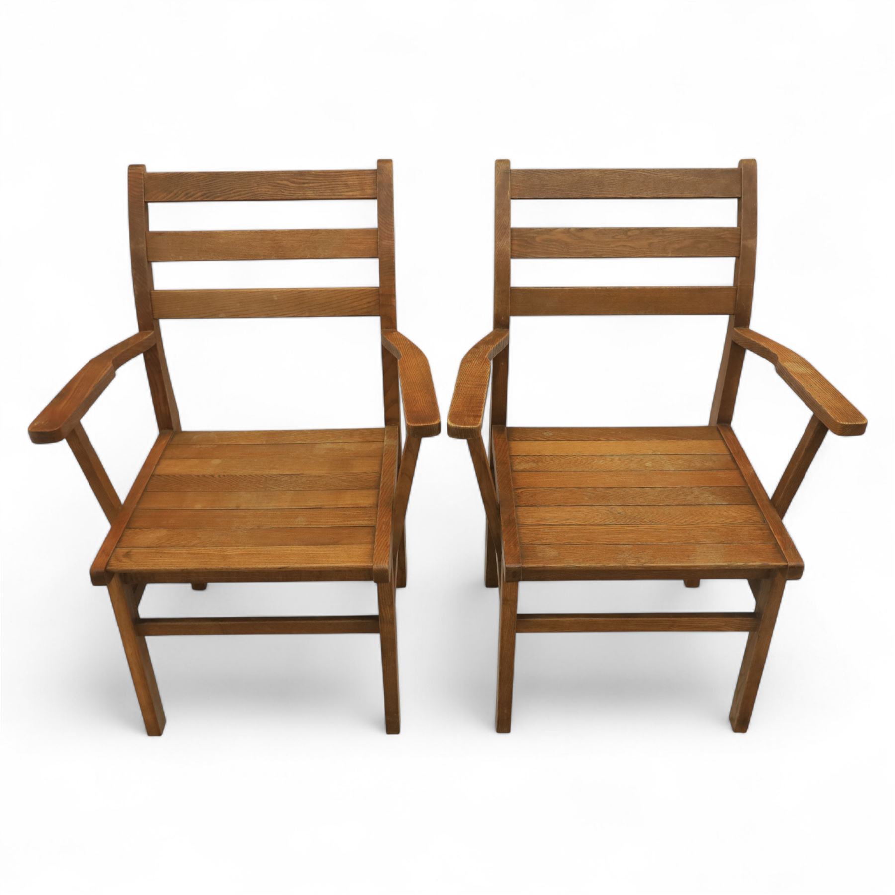 Treske of Thirsk - solid oak refectory dining suite, rectangular top with chamfered edge over trestle base united by a central stretcher, together with six matching slat back dining chairs, including two carvers, with panelled seats and square legs united by stretchers (H 87cm, W 62cm, D 57cm)