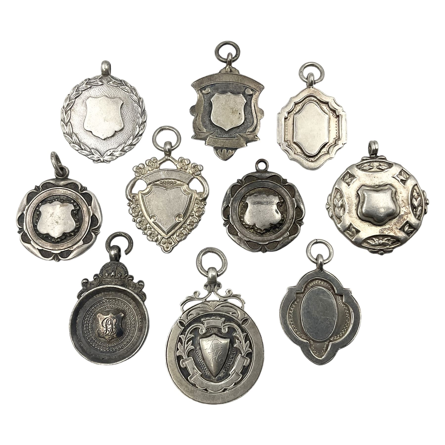Ten early 20th century silver cartouche fobs, to include a Yorkshire Rose example, all hallmarked with various dates and makers

