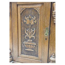 Late 19th century pine dresser, the projecting cornice with dentil and spindle moulded frieze above a three-tier plate shelves, flanked by glazed doors, the base fitted with three frieze drawers over arched apron and carved floral panelled cupboard doors, raised on turned feet