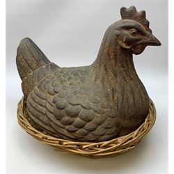 A large cast iron model of a hen, probably Victorian, seated upon a wicker basket nest, H38cm, L43cm