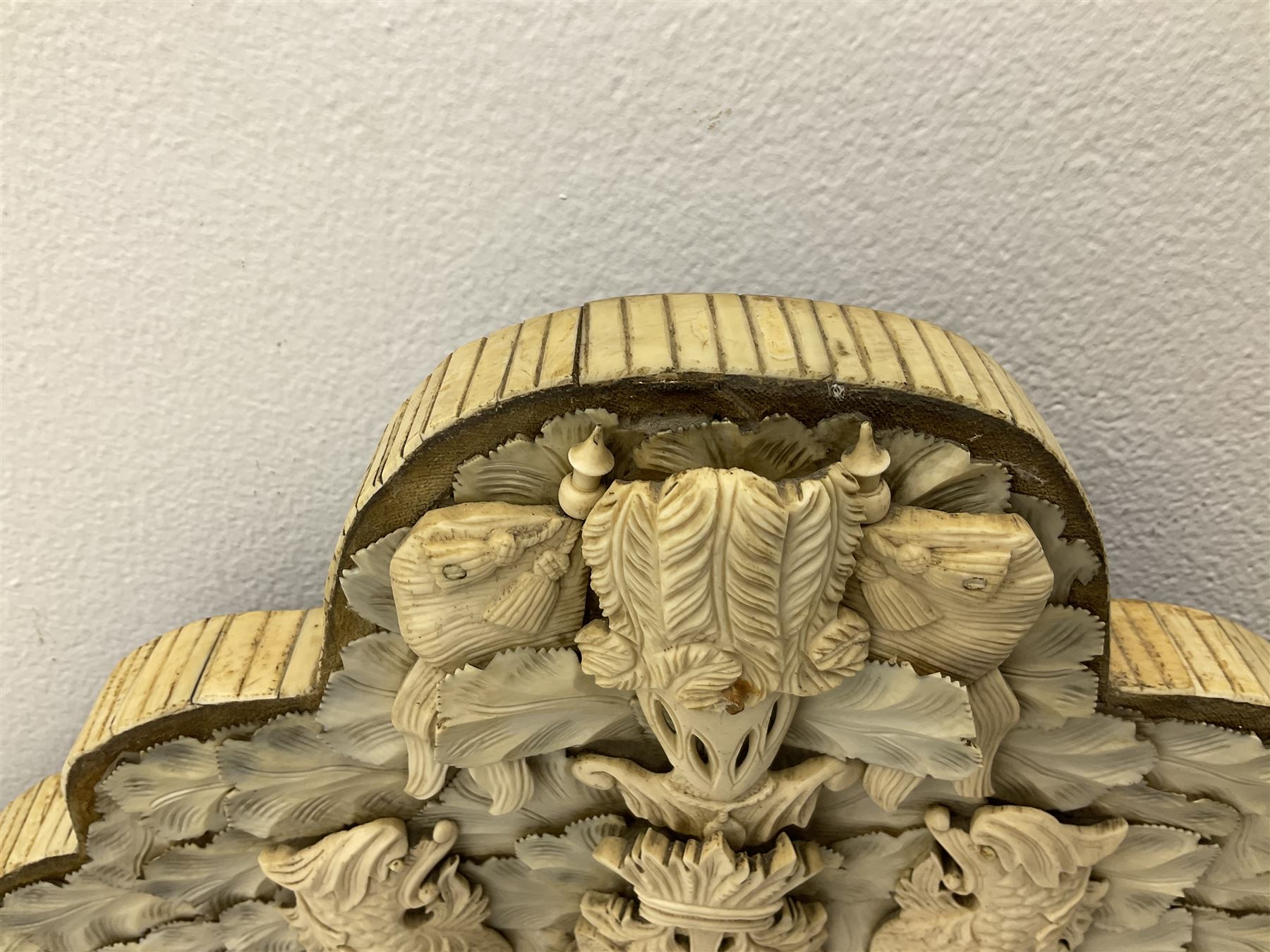 Pair 19th century French Dieppe bone and ivory wall mirrors, the oval bevelled mirror plates within rectangular frames with shaped tops, profusely decorated with ivory leaves, further detailed with carved bone armorial type crest inscribed 'SGOTORVM', putti, fish and mask heads, H81cm W48cm