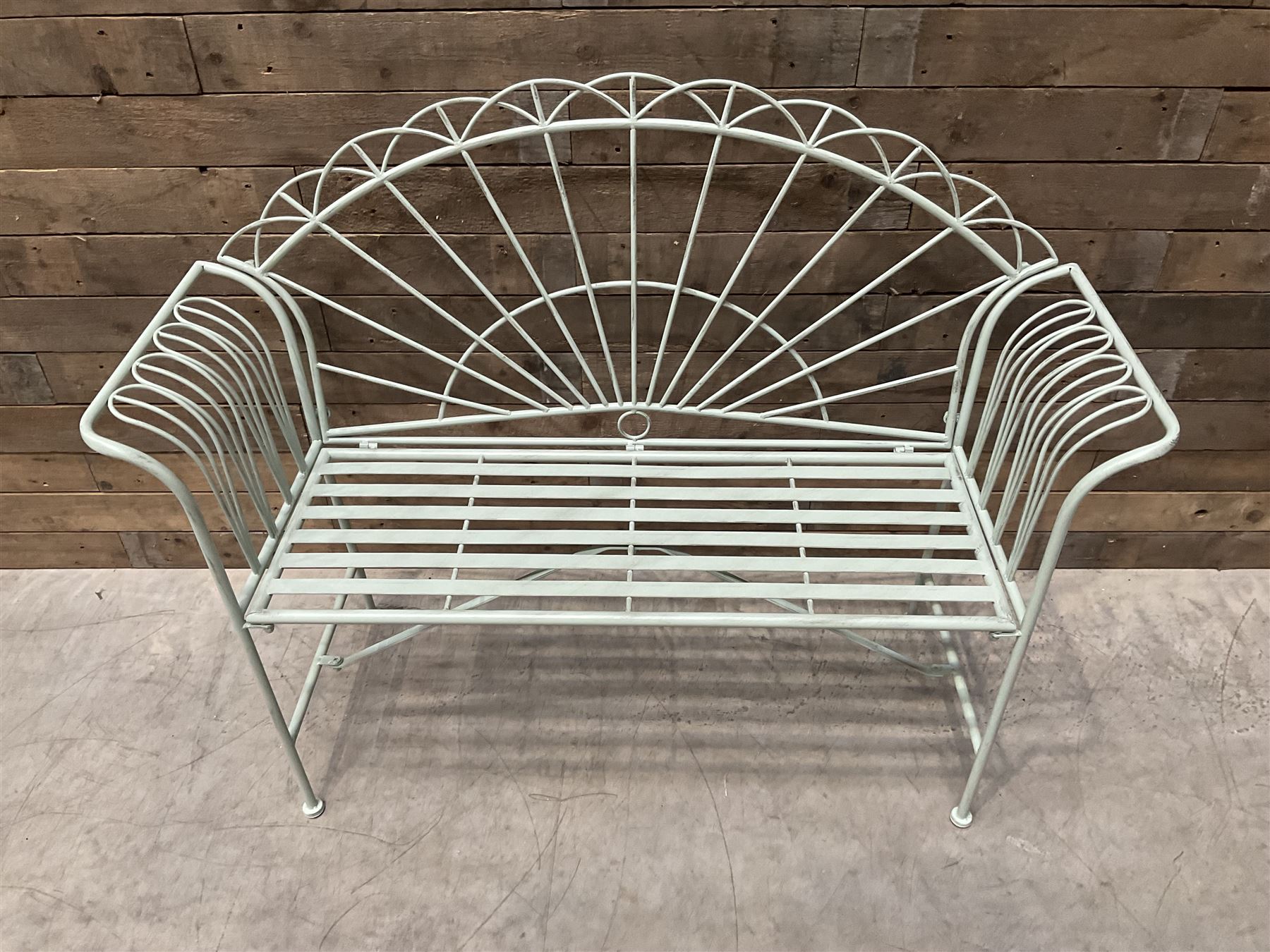 Wrought metal two seat garden bench, sunburst back, painted in pale green finish