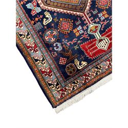 Persian Ardabil indigo ground rug, four interconnected lozenge medallions surrounded by ewer, bird, dragon, camel and geometric motifs, hooked border within guard stripes 