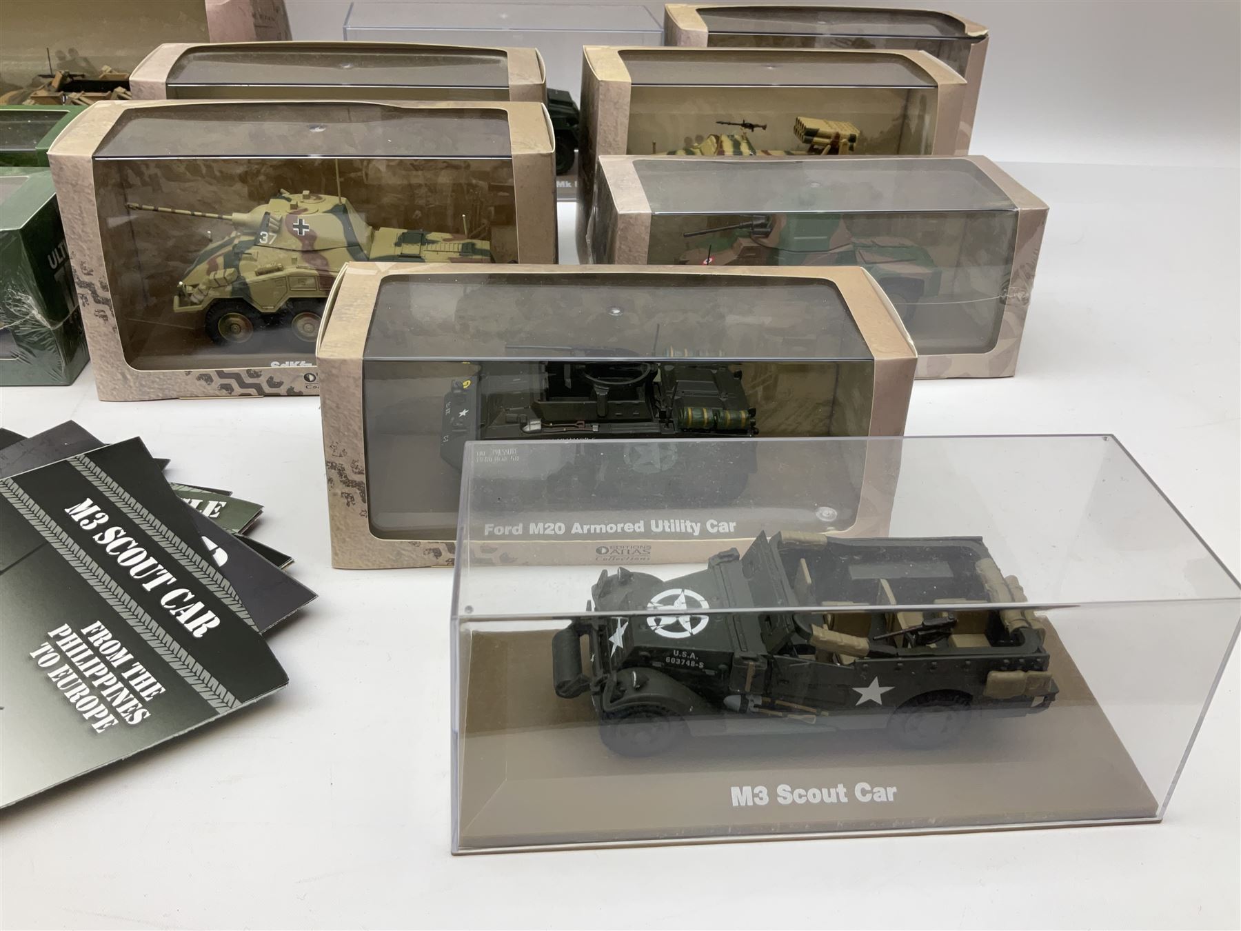 Sixteen Atlas Editions die-cast models of military vehicles including six Ultimate Tank Collection; all in perspex display cases; fourteen boxed; with associated paperwork (16)