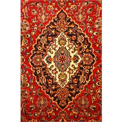  Kashan red ground rug, floral field, repeating border, signed by the weaver, 218cm x 142cm  