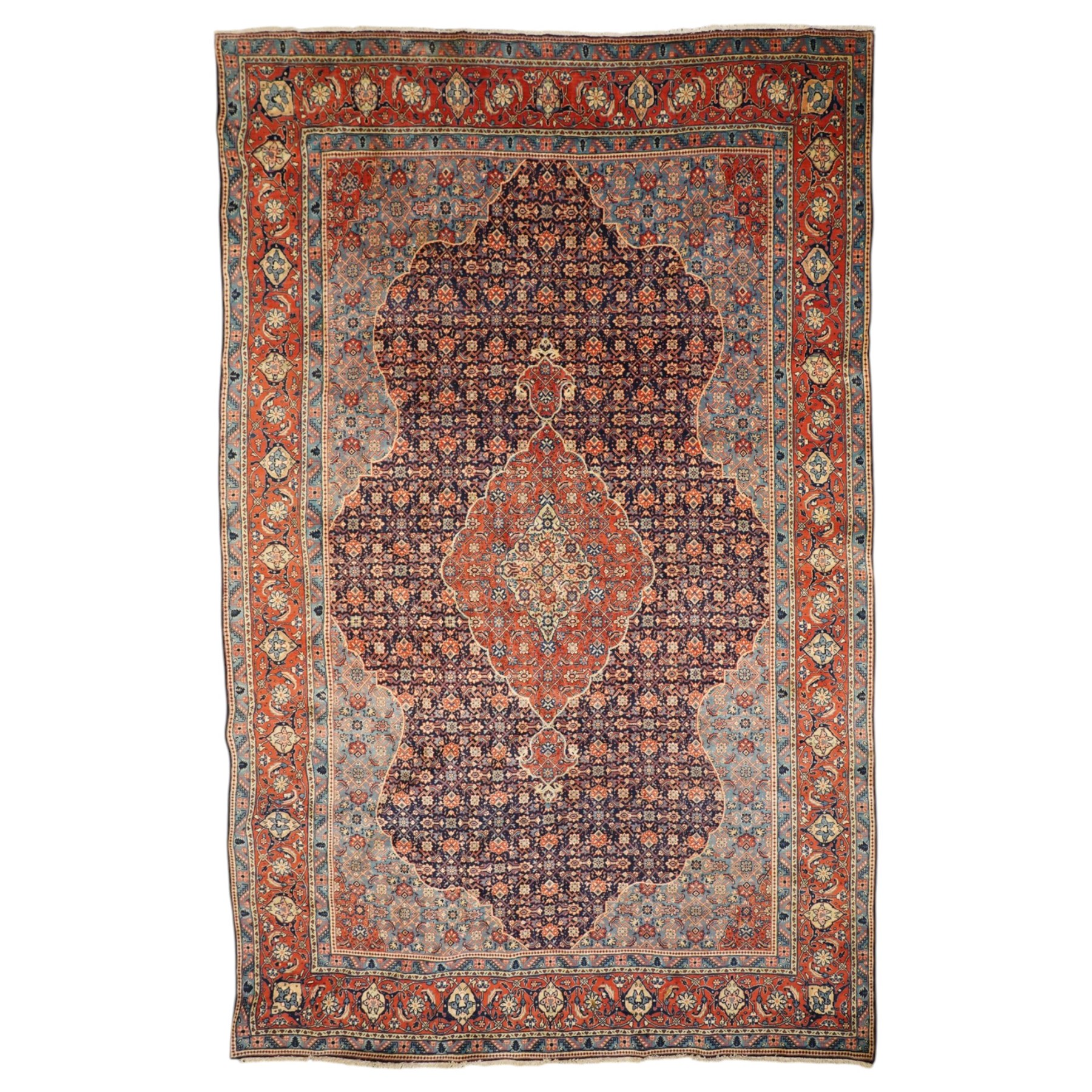 Persian indigo ground Herati rug, the busy field with a central lozenge pole medallion surrounded by repeating Herati motifs, within a shaped spandrel border the crimson guard band decorated with repeating palmette motifs