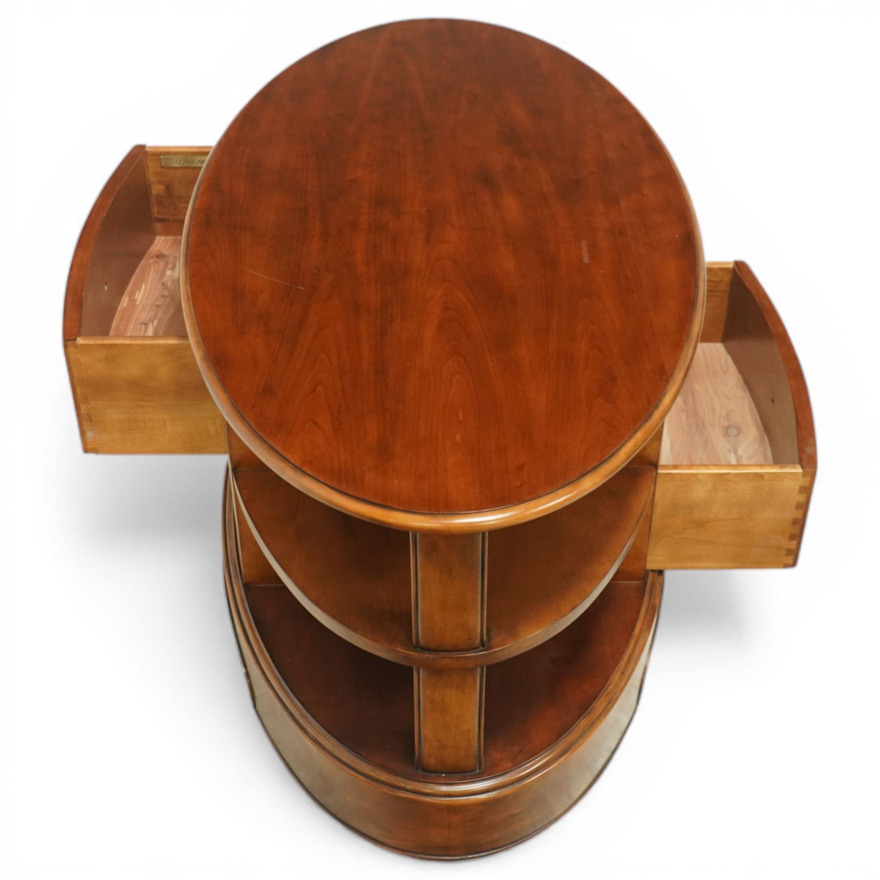 Willis & Gambier - oval coffee table, the moulded oval top above two central frieze drawers with handles either side, flanked by open shelves, raised on a shaped plinth base