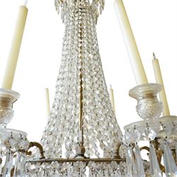 Regency Country House cut-glass and ormolu six light chandelier, the outer shaft with ormolu foliate moulding hung with octagonal and drop pendants, the impressive central shaft with cascading drops of cut-glass, the scroll branches with hob-nail cut candle holders and wax pans, with central similarly cut terminal
Provenance: property of a nobleman