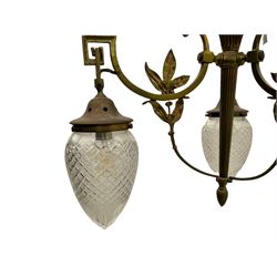 Early 20th century brass chandelier, central flute with three projecting scrolled branches decorated with foliage, fitted with three cut glass shades 