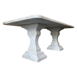 Classical Grecian design Carrera marble centre table, the rectangular single slab top with rounded corners and carved edge, raised on twin pedestals comprised of three pieces with a waisted column on a stepped plinth