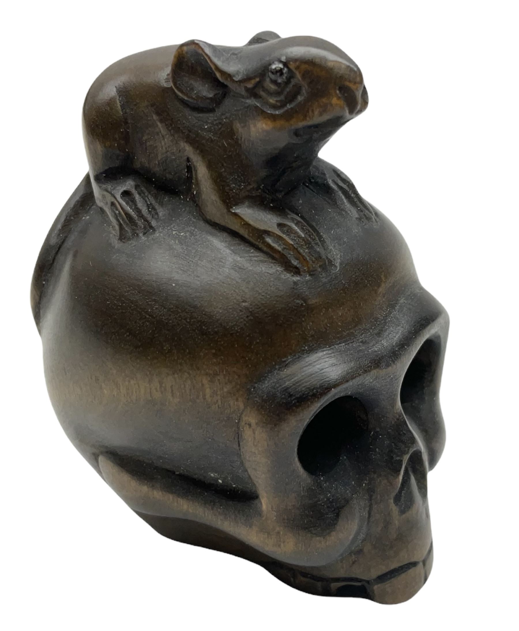 Netsuke in the form of a rat sitting on a skull, signed to the base
