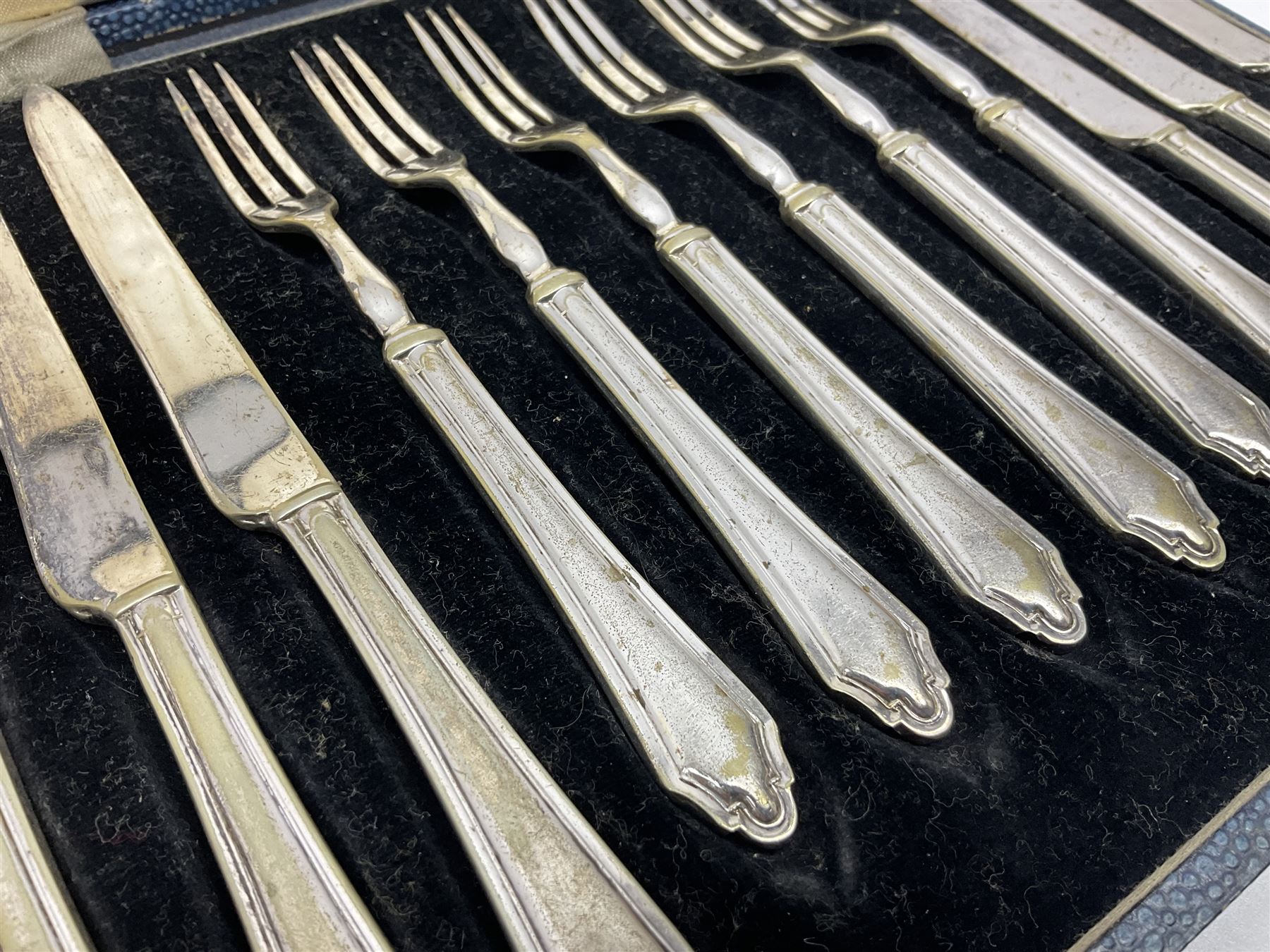 Set of six stag horn handled knives by Cooper Brothers and Sons, together with a set of silver plated dessert knives and forks for six place settings, both within fitted cases
