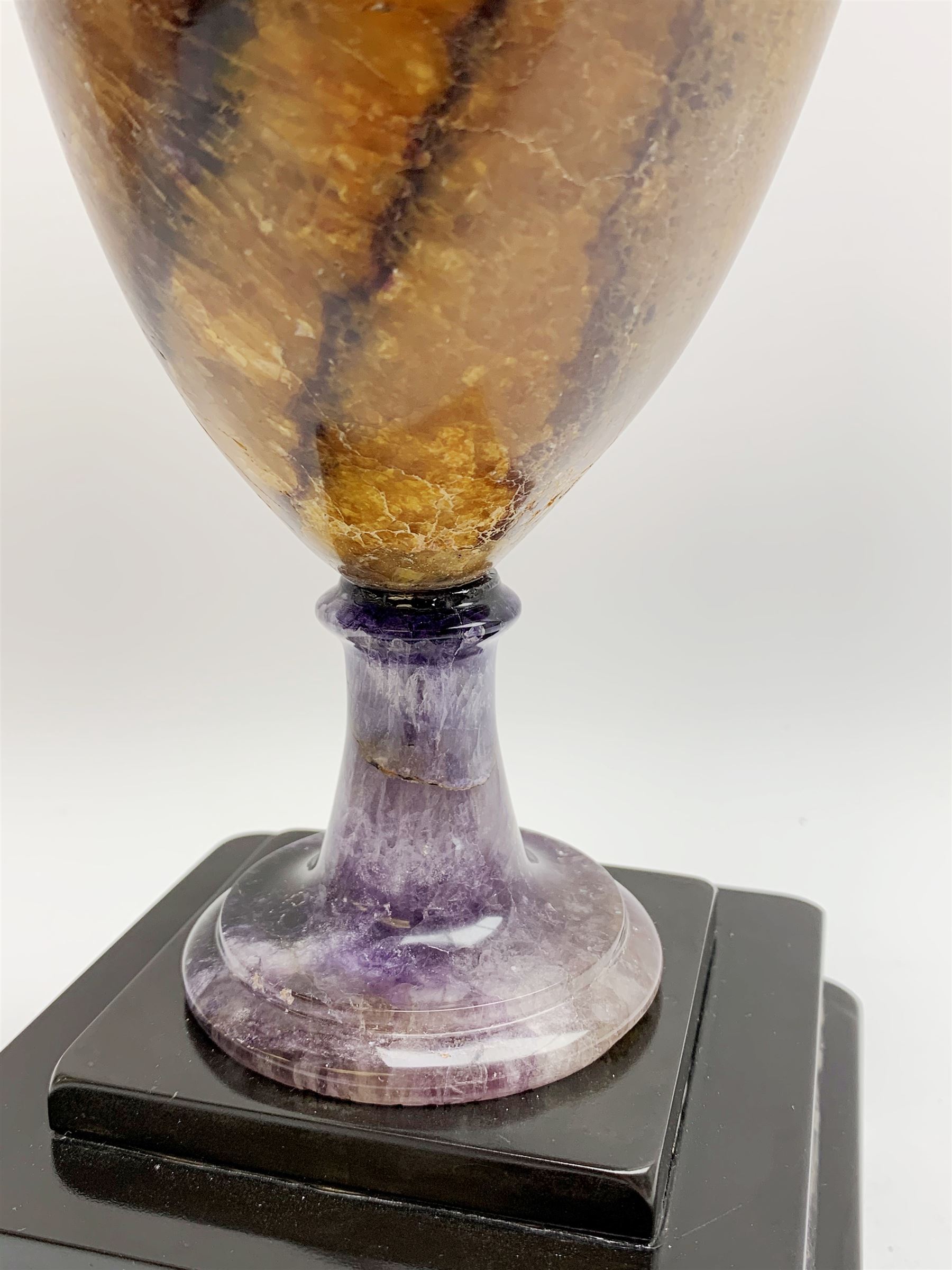 Early 19th century and later Blue John urn, Winnats one vein, of ovoid form with integrated cover and ball finial, upon a spreading circular base, and square stepped black lacquered base, H34.5cm