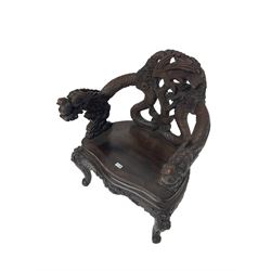 Japanese Meiji period open armchair, the back carved and pierced with dragon and scrolling scaled tails, projecting dragon carved arm terminals on scrolled supports, serpentine seat with decorative band, the apron and supports with scroll and chip-carved decoration
