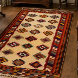South West Persian Qashqai flatweave kilim, ivory field decorated with rows of multicoloured stepped diamond medallions composed of angular geometric motifs, enclosed by bold polychrome borders of triangular devices and stylized geometric, ornamentation, with fringe ends 