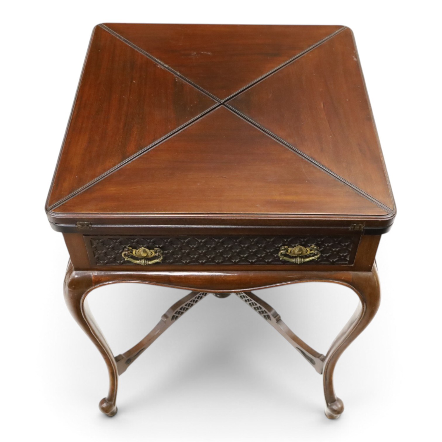 Edwardian carved mahogany envelope card table, the rectangular quadruple hinged top enclosing baize-lined interior, the single frieze drawer and sides with blind-fretwork carving, over cabriole supports with scroll feet and castors united by pierced lattice fretwork X-stretcher with turned finial