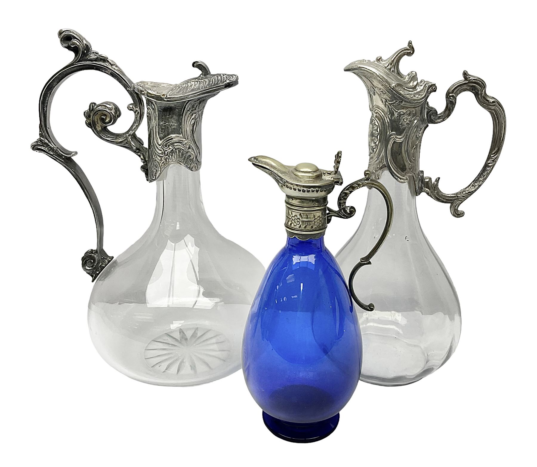 Silver plate mounted blue glass claret jug of ovid form, with C scroll handle, together with two other silver plate mounted claret jug