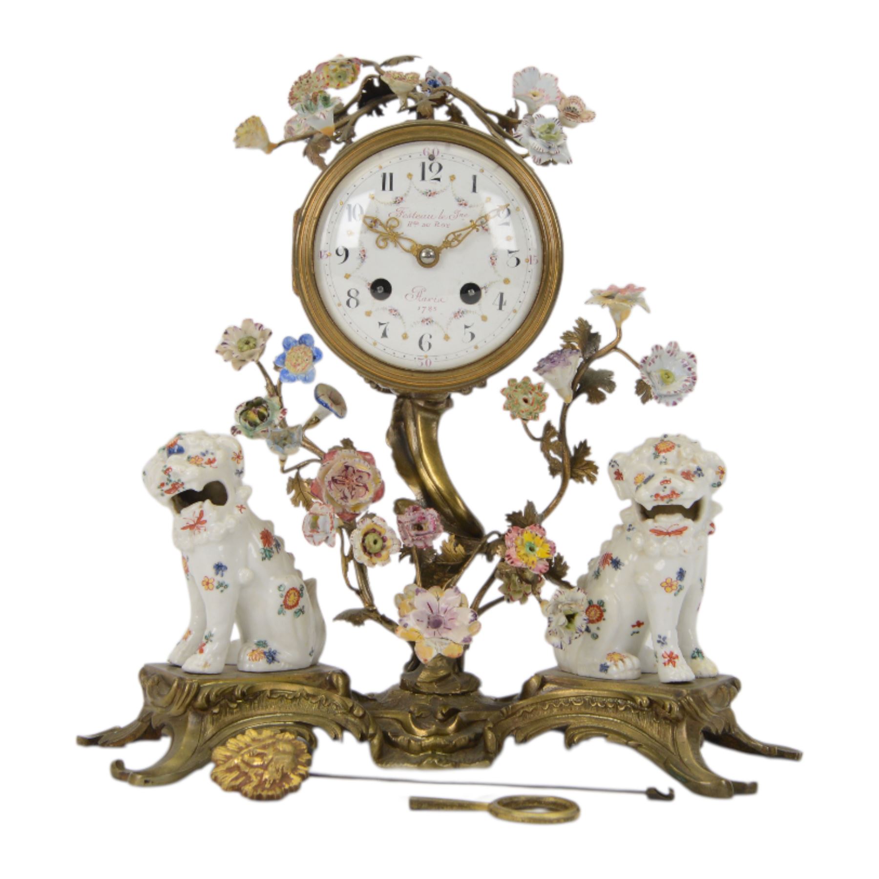 French- early 20th century 8-day Chinoiserie brass and porcelain mantel clock in the 18th century style, brass base with splayed feet profusely decorated with clusters of painted porcelain flowers and two decoratively painted Chinese foo dogs, movement enclosed in a circular porcelain movement case illustrated with birds of paradise and oriental motifs, with a white enamel dial Arabic numerals, minute markers, pierced gilt hands and a floral swag, rack striking Parisian movement striking the hours and half-hours on a bell. With a visible sunburst pendulum and key.