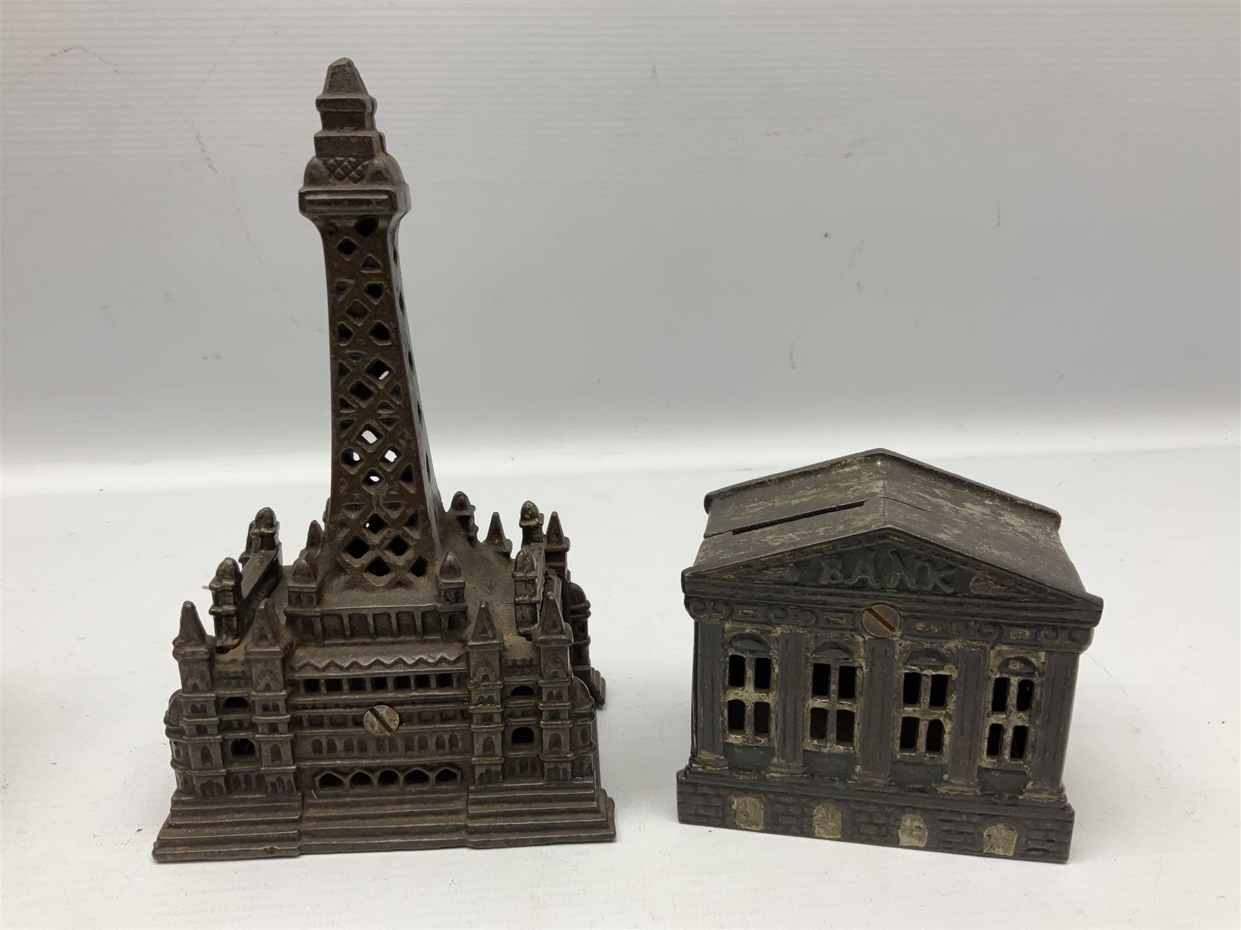 Five early 20th century cast-iron money banks as buildings - 'City Bank' c1904 H10cm; 'County Bank' c1905 H11cm; 'Town Hall Bank' c1900 H8.5cm; 'Tower Bank' c1902 H23.5cm; all made by John Harper; and 'Blackpool Tower Bank' c1907 by Chamberlain & Hill H18.5cm (5)