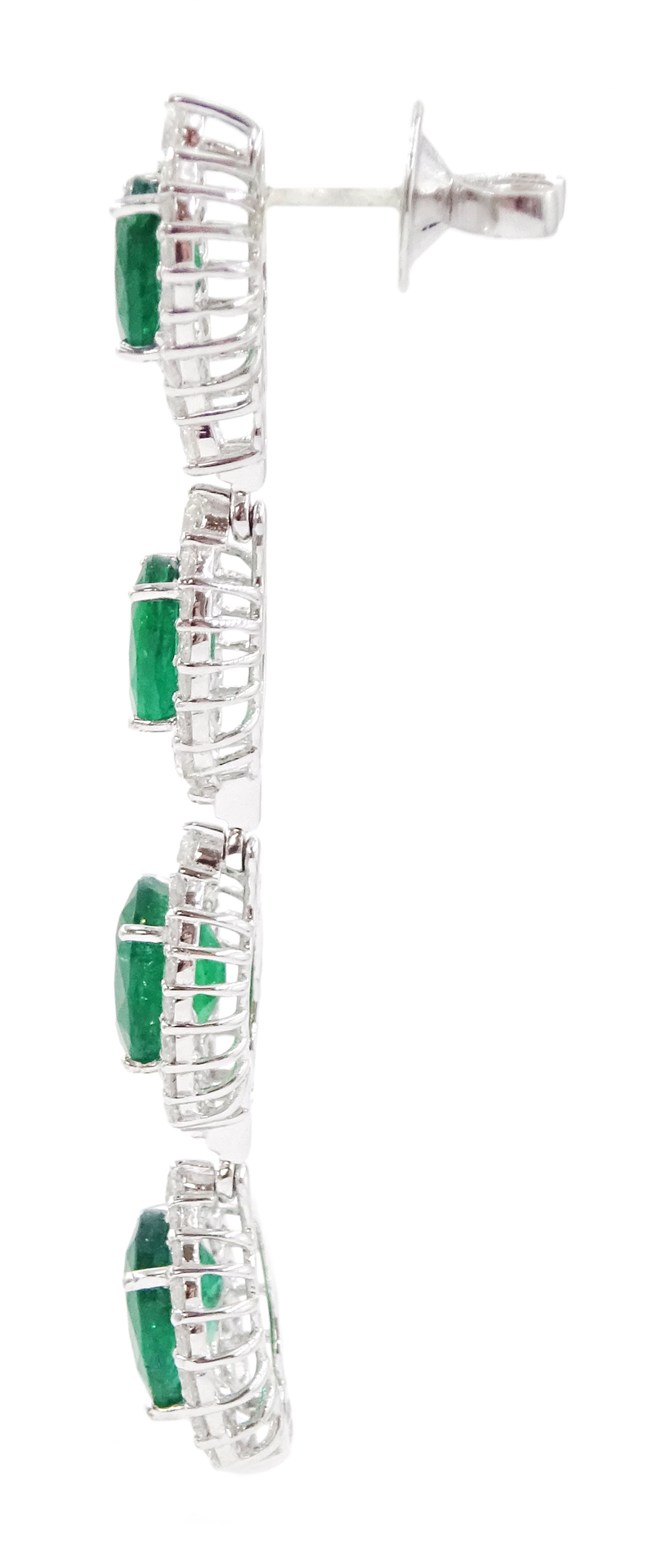 Pair of 18ct white gold graduating emerald and diamond pendant stud earrings, oval cut emerald and round brilliant cut cluster, suspending a single round brilliant cut diamond and three further emerald and diamond clusters, stamped, total emerald weight approx 8.65 carat, total diamond weight approx 3.30 carat