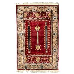Persian red ground rug, the field with extending motifs enclosed by end panels decorated with stylised plant motifs, the main border with repeating pattern 