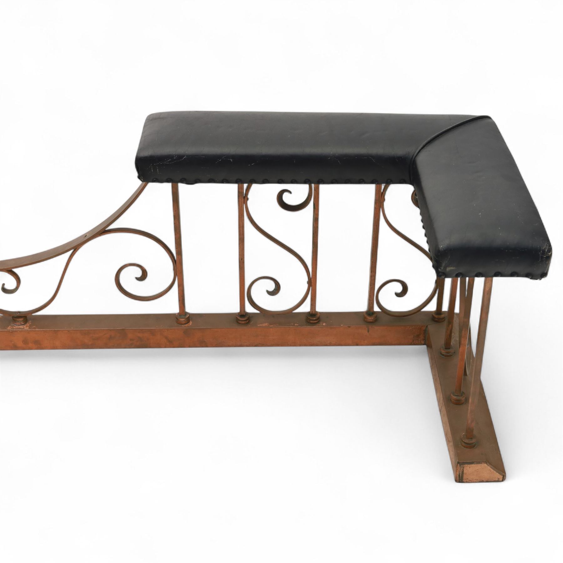Early 20th-century Arts & Crafts copper club fender, of long serpentine form, scrolling uprights and a shaped centre support, the top rail fitted with four upholstered padded seat sections, raised on a stepped plinth base, inner dimensions 192x43cm 