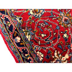 Central Persian Kashan crimson ground runner rug, the field decorated with interlacing branch and stylised flower head motifs, the guarded indigo border with repeating trailing foliate patterns