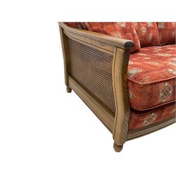 Ercol medium elm framed three seat bergere sofa, and pair of matching armchairs upholstered in red fabric