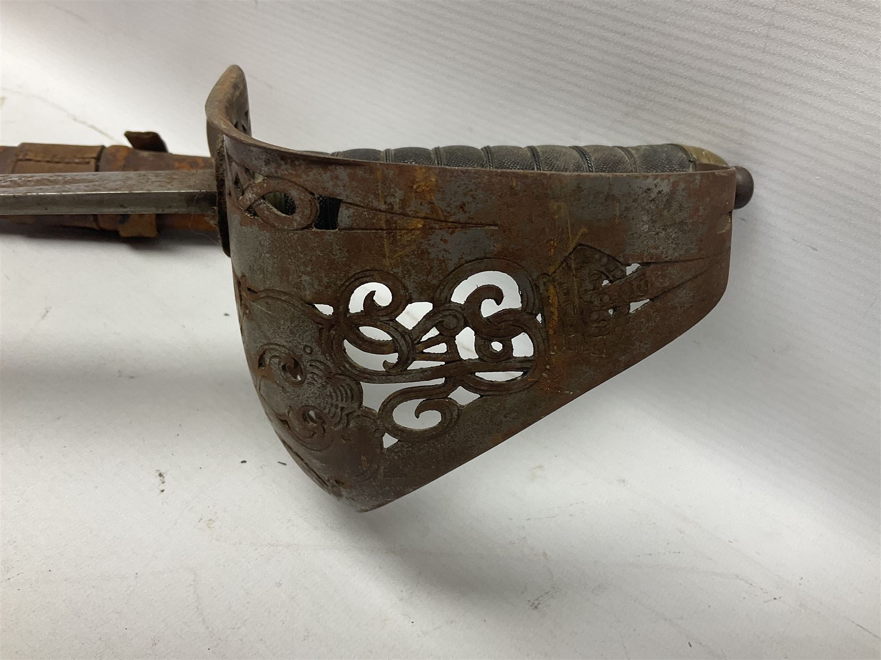 George V 1897 pattern Infantry officers sword, the 82cm single fullered blade with traces of etched detail and George V crown cipher, the ricasso marked Hawksworth Sheffield, pierced half basket hilt with George V cypher, wire-bound fish-skin grip with brass pommel and backstrap; in leather scabbard L102cm overall; together with two sectional gun cleaning rods; swagger stick made of leather strips etc