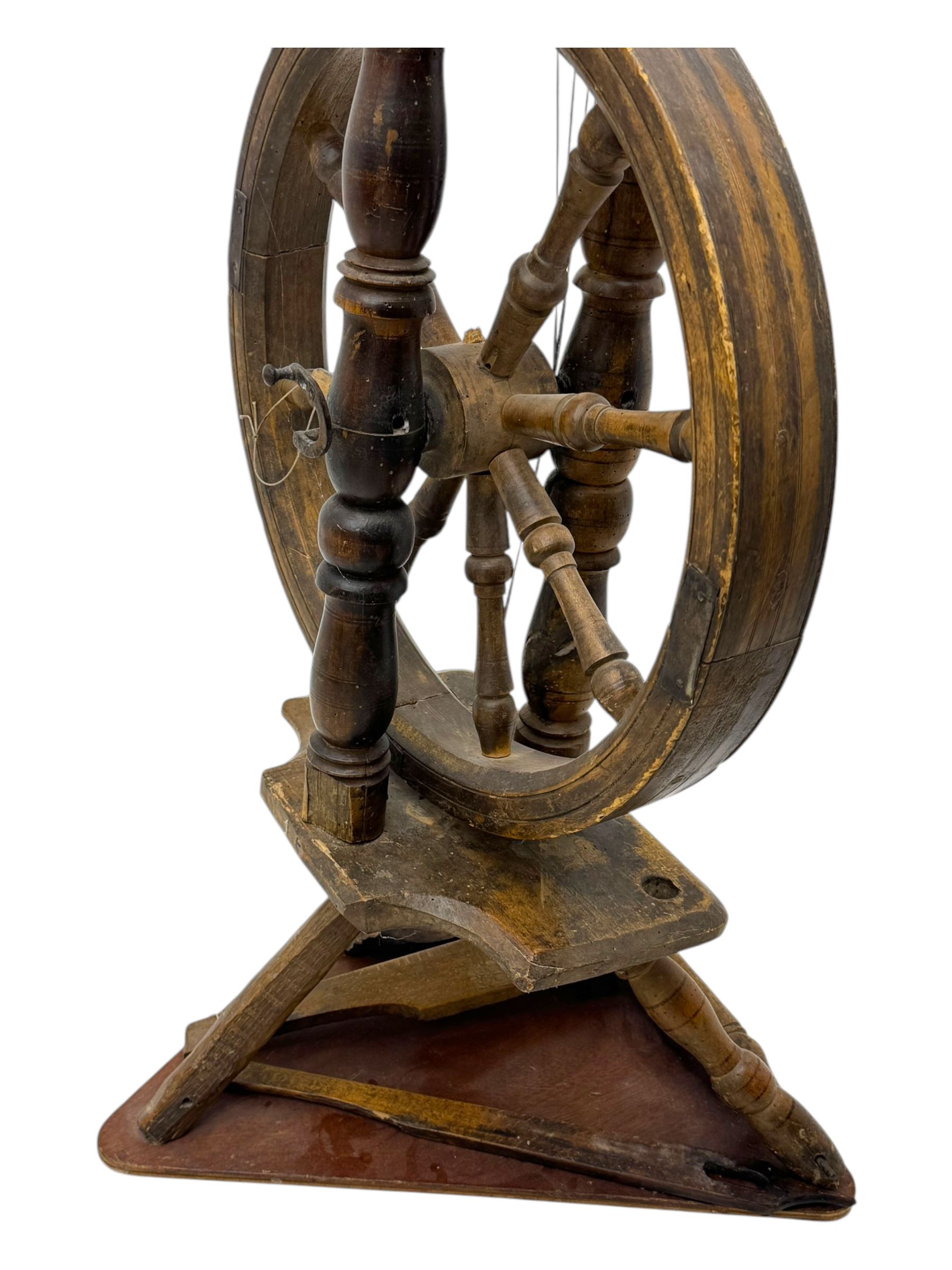 Late 19th century turned beech spinning wheel, upright form with single treadle, triangular base, and a flyer and bobbin assembly surmounted by a turned finial.