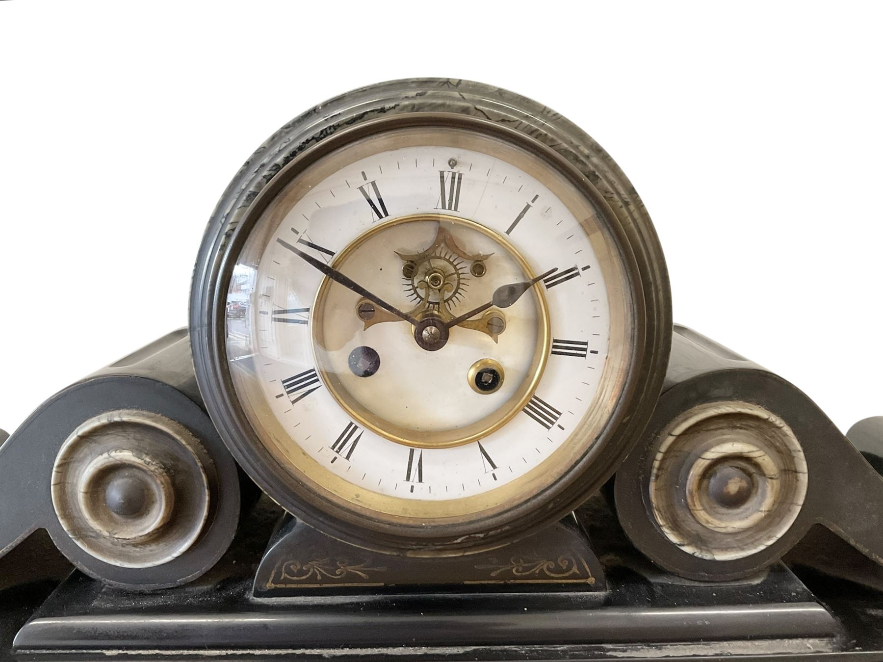French- late 19th century 8-day Belgium slate and marble mantle clock, drum movement with volutes and conforming scroll side pieces, on a stepped plinth with incised decoration to the front, two-piece enamel dial with a visible Brocot deadbeat escapement, spade hands and Roman numerals, twin train, countwheel striking movement, sounding the hours and half-hours on a bell. With pendulum and key. 