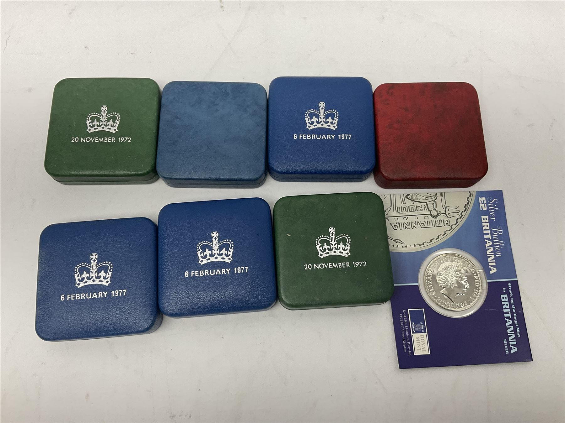 Seven The Royal Mint United Kingdom sterling silver proof crown coins, comprising two 1972, three 1977, 1981 and 1993, all cased with certificates and a Queen Elizabeth II 2001 one ounce fine silver Britannia coin on card (8)