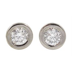 Pair of 18ct white and yellow gold round brilliant cut diamond stud earrings, rubbover set, stamped 750, total diamond weight 0.62 carat