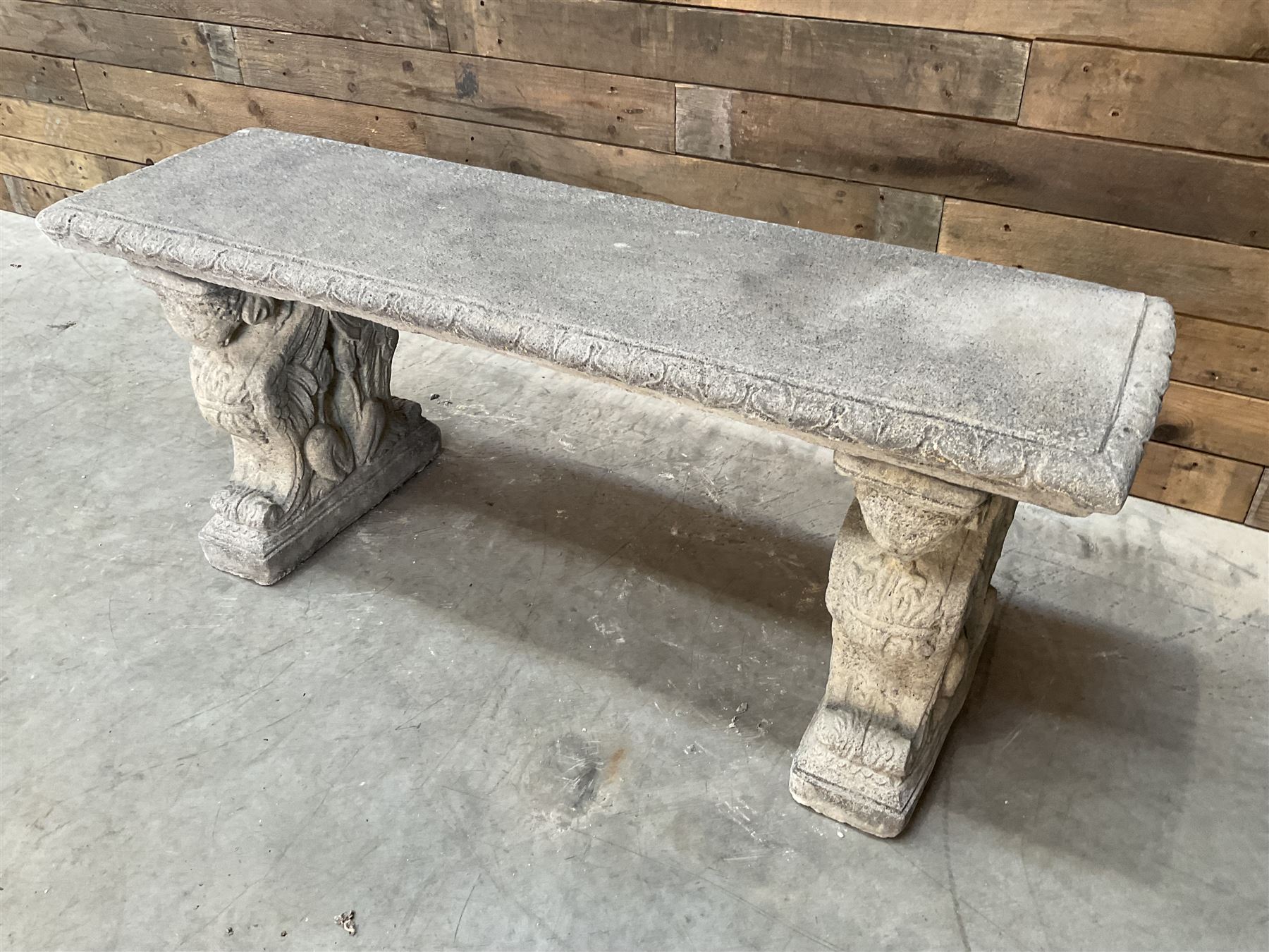 Cast stone garden Rams Head bench, two pillars set with architectural rams heads, rectangular slab seat