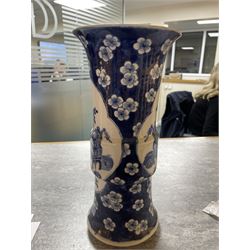 Late 19th century Chinese blue and white gu beaker vase, decorated with two lobed reserves containing precious objects, against a prunus and cracked ice ground, with apocryphal Kangxi mark beneath, H30.5cm