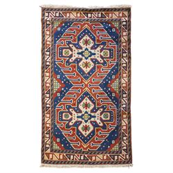 Caucasian Kazak indigo and vermillion ground rug, the geometric field boldly woven with tw...