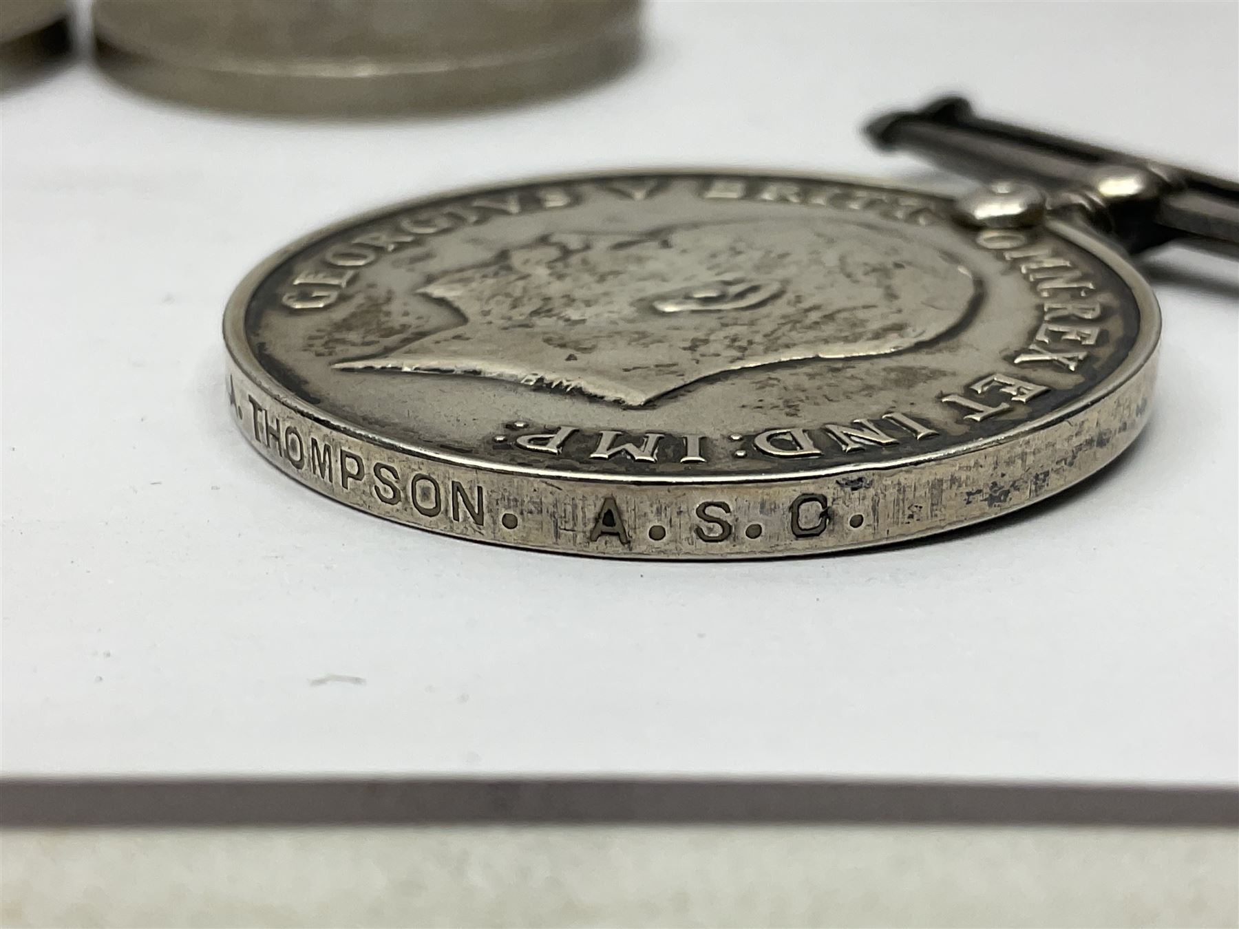 WWII group of five medals comprising 1939-45 War Medal, Defence Medal, 1939-45 Star, Africa Star and France and Germany Star on wearing bar; WWI British War Medal awarded to 142019 Pte. A. Thompson A.S.C.; and boxed King's Badge 'For Loyal Service'