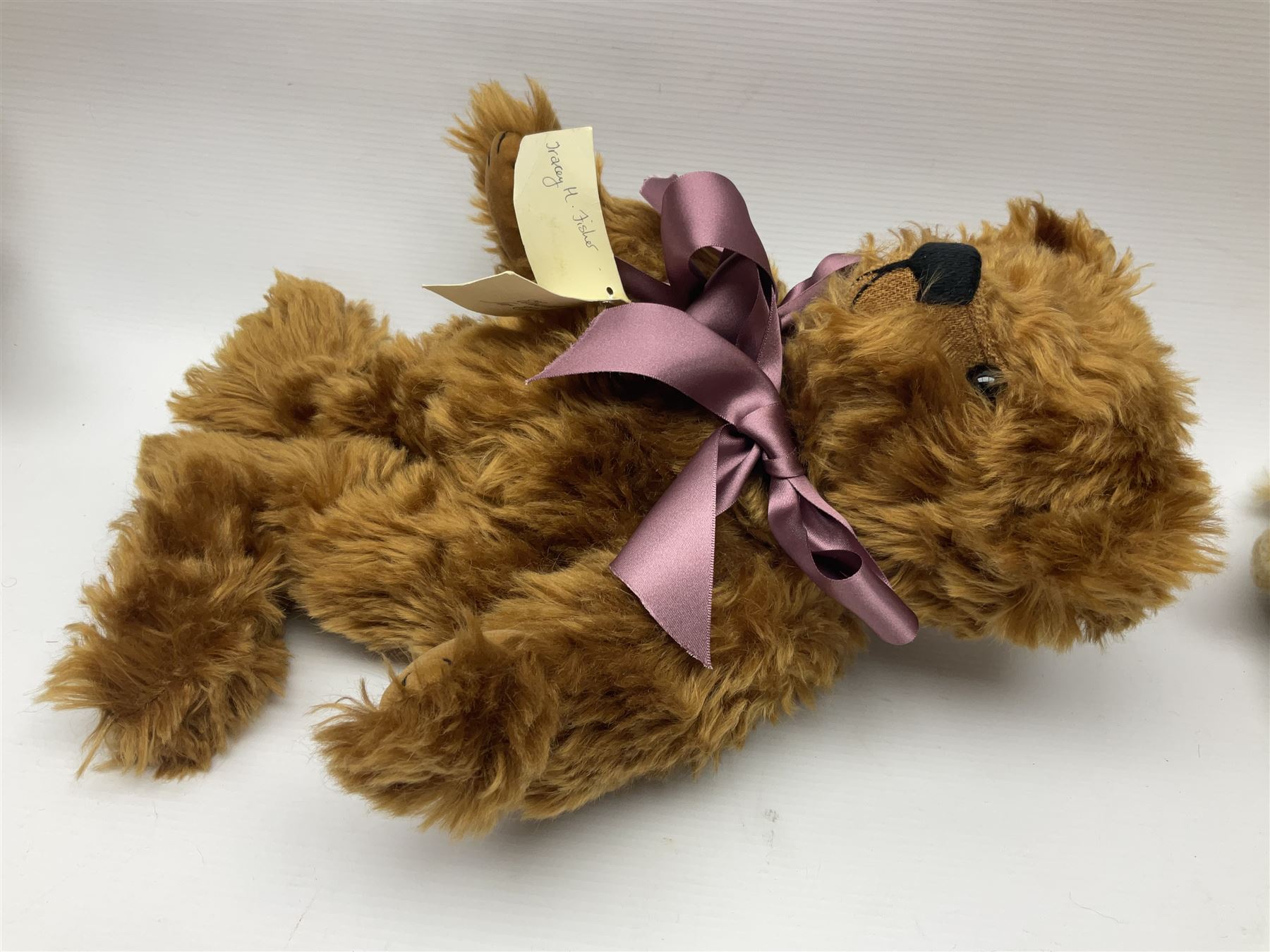Group of five teddy bears comprising ‘George’ a unique pellet filled bear with glass eyes and velvet paws H38cm, and ‘Abbey’ a luxury German plush with wobble head and glass eyes no.5/10 H24cm, both with Teddies from Bearyland labels; along with two light blonde mohair H. M. Bears and Boyds Bears ‘T. F. Wuzzies’ no. 595140 (5)