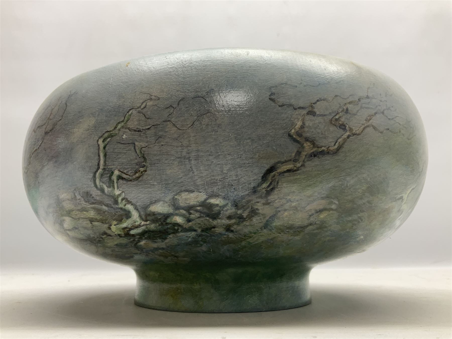 Wooden hand painted bowl, decorated with trees on a blue ground, signed Phil Crennell beneath, D28cm