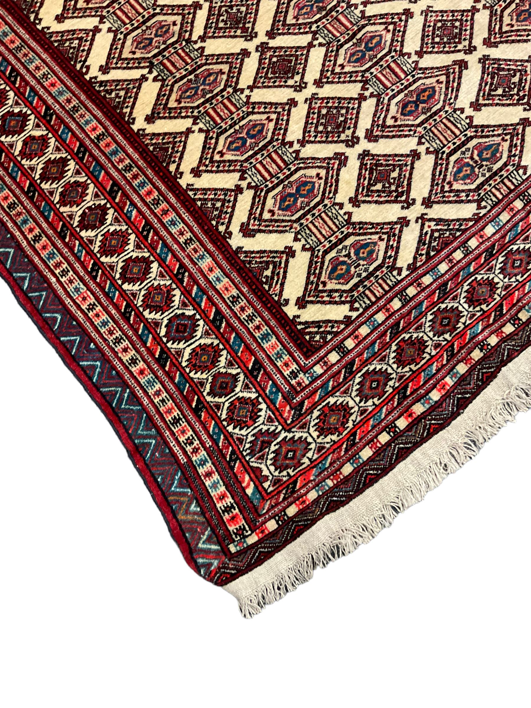 North East Persian Turkoman rug, ivory ground field decorated with repeating Gul motifs, multi-band border decorated with geometric patterns and motifs