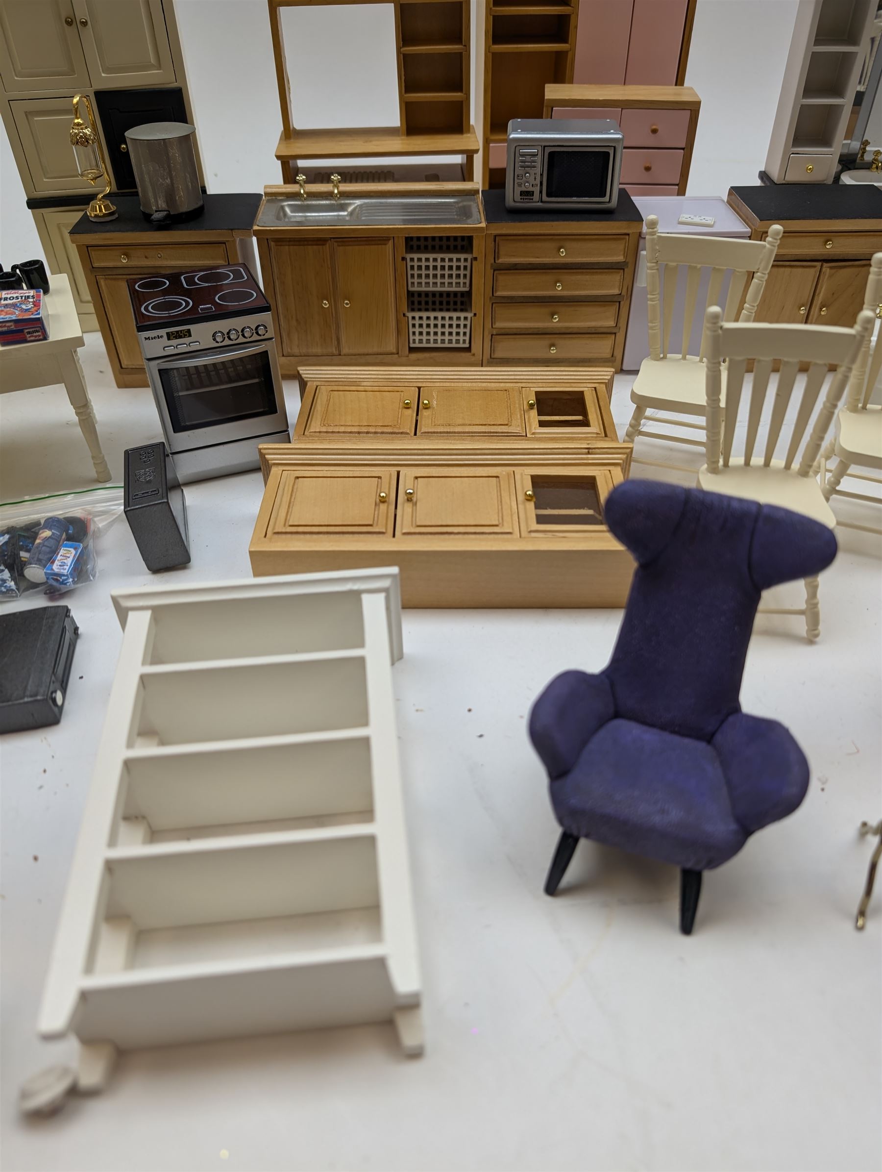 Modern 1:12 scale dolls house furniture, comprising pine kitchen set, with wall cabinets, floor cabinets and sink unit, white wooden bathroom suite, white wooden kitchen and dining room furniture and appliances, wooden bedroom furniture, Raine purple wingback chair, tv, desk, fish tank, etc