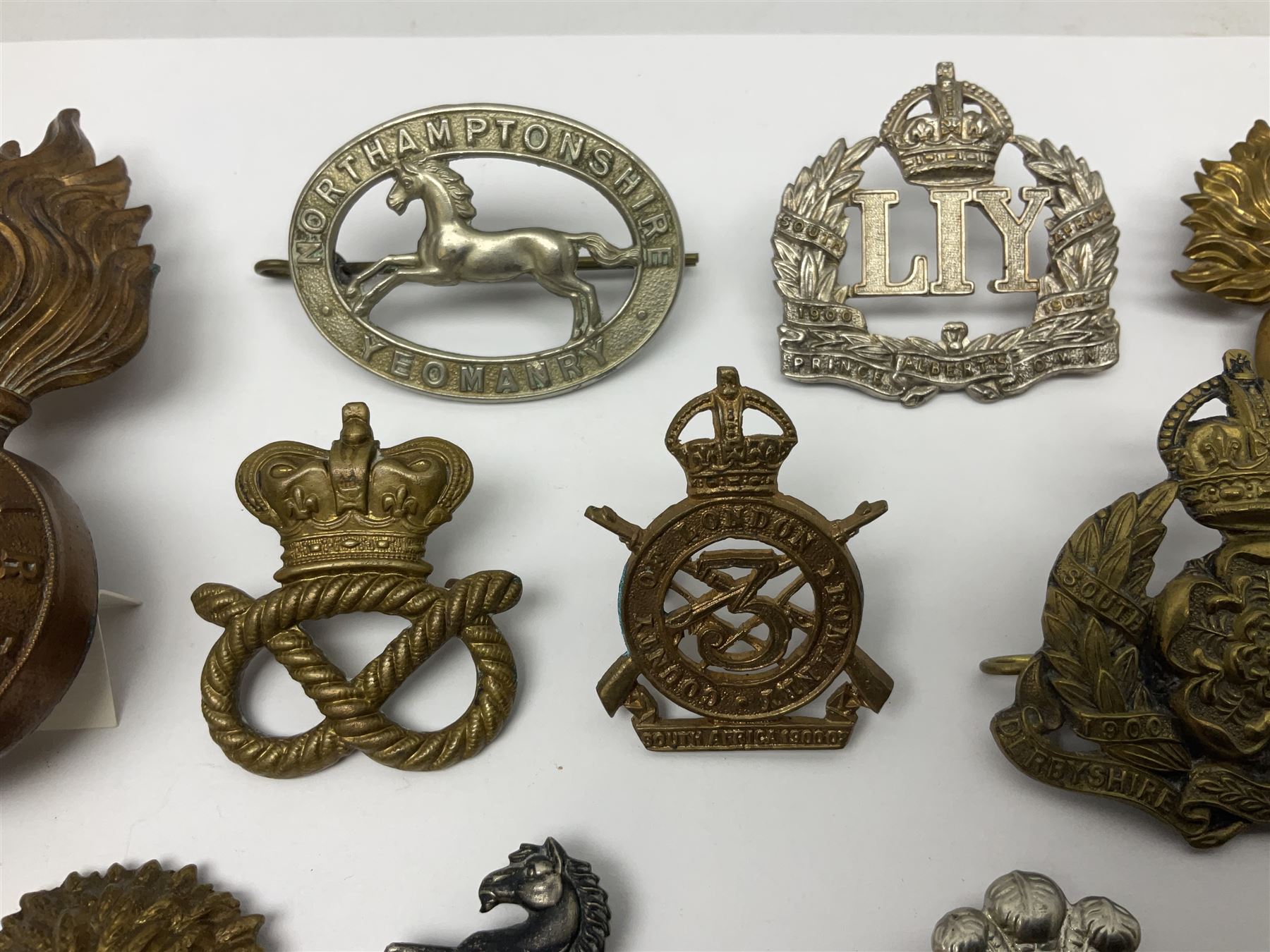 Nineteen Yeomanry metal cap badges including Derbyshire, Northamptonshire, Essex, Glamorgan, Staffordshire, City of London, Surrey, Shropshire, Hertfordshire etc; together with eleven Fusiliers badges including Lancashire, Royal Welch, Northumberland etc (30)