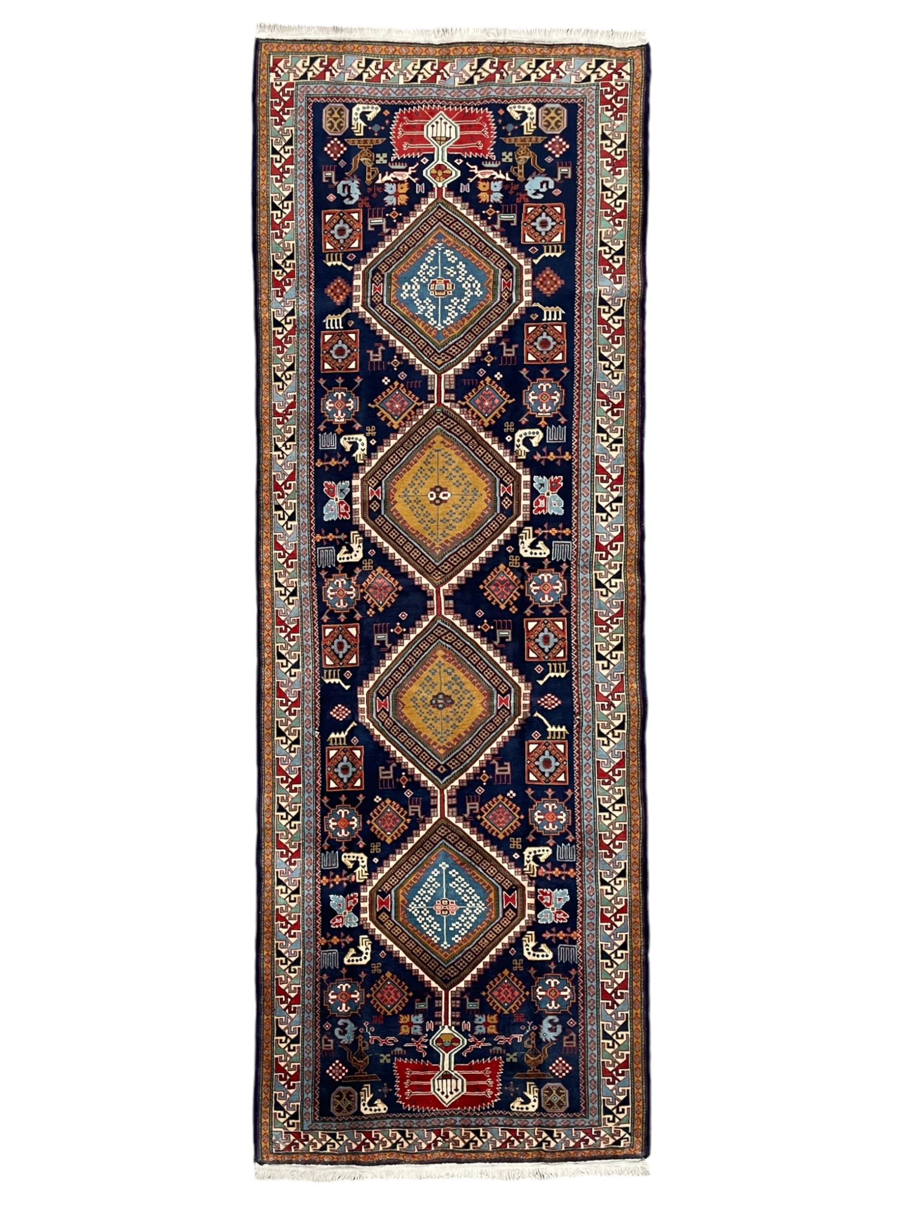 Persian Ardabil indigo ground rug, four interconnected lozenge medallions surrounded by ewer, bird, dragon, camel and geometric motifs, hooked border within guard stripes 