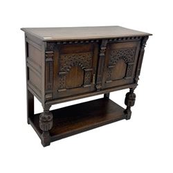 Jacobean design carved oak two door cupboard, the frieze and twin cupboard doors carved with arcaded panels and stylised foliage, raised on baluster supports united by an undertier