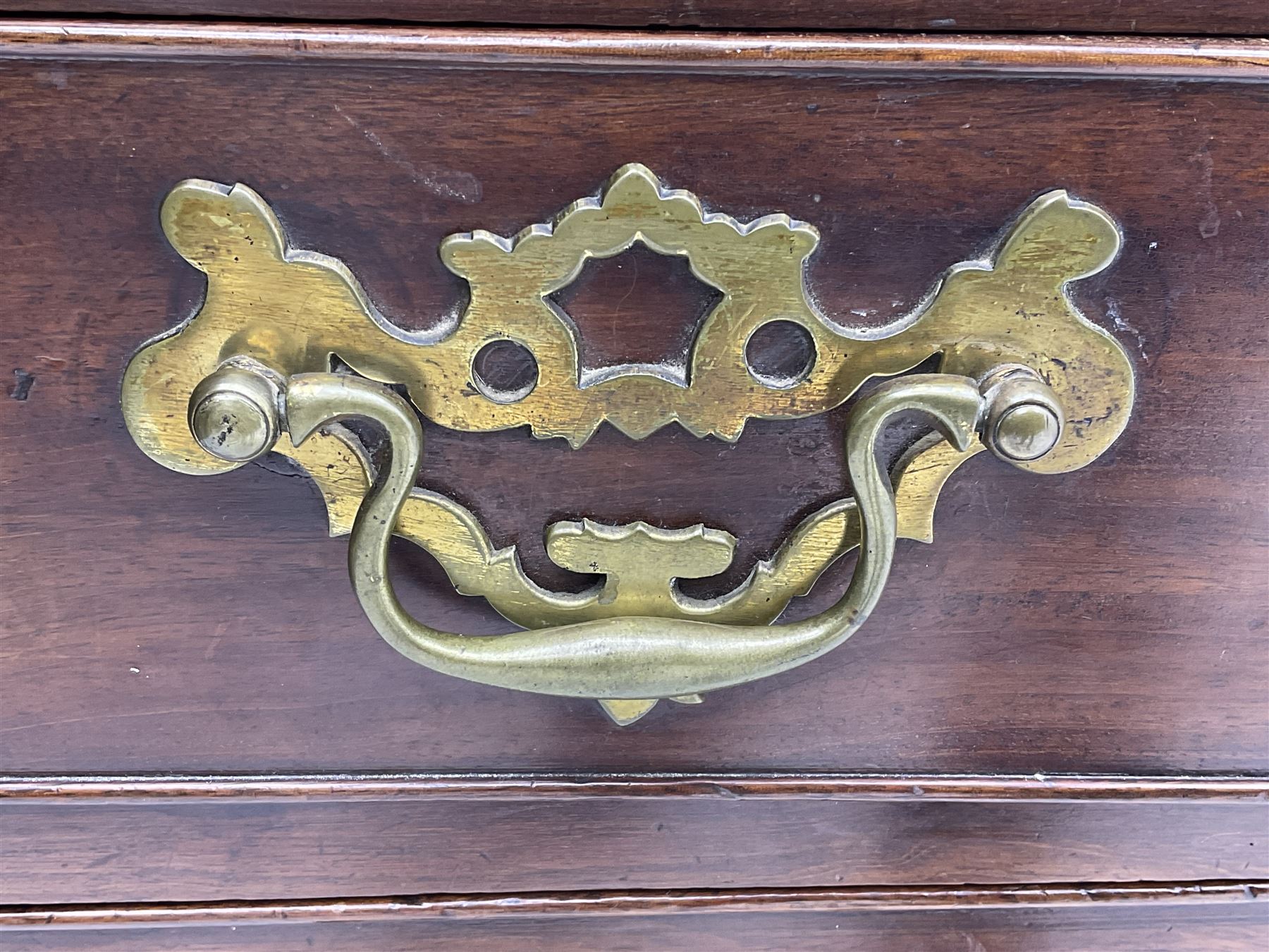 George III mahogany bureau, the conch inlaid fall front enclosing pigeon holes, shelves and central cupboard with inlaid flower motif, four graduating cock-beaded drawers below each with brass handles, lower moulded edge over shaped bracket feet