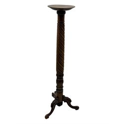 Late 19th century mahogany torchère stand, with circular top above a twisted and foliate carved collumn, on a scroll carved tripod base, on cabriole legs